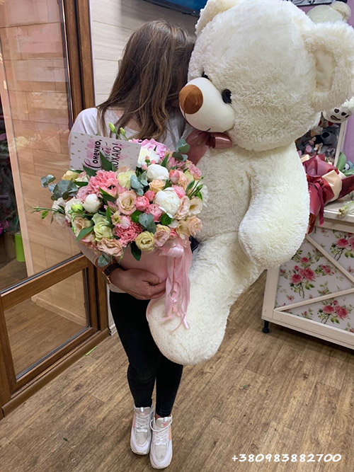 Большой плюшевый медведь и букет цветов