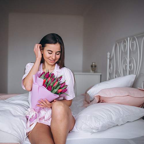 дівчина з букетом в номері готелю фото дівчини з букетом в готелі